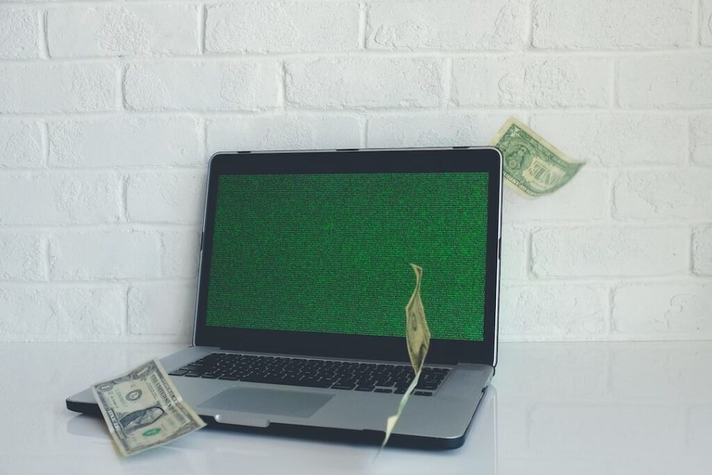 Un ordenador portátil con un gráfico de barras ascendente y un símbolo de dinero al lado